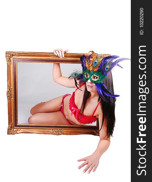 Lovely woman in red lingerie with a mask over her face looking through a picture frame with gray background inside and white background outside. Lovely woman in red lingerie with a mask over her face looking through a picture frame with gray background inside and white background outside.