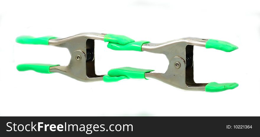 A pair of metallic clamps over white