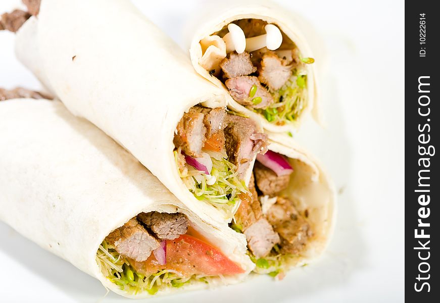 Sliced beef in a wrap with sprouts, mushrooms, and tomato. Sliced beef in a wrap with sprouts, mushrooms, and tomato