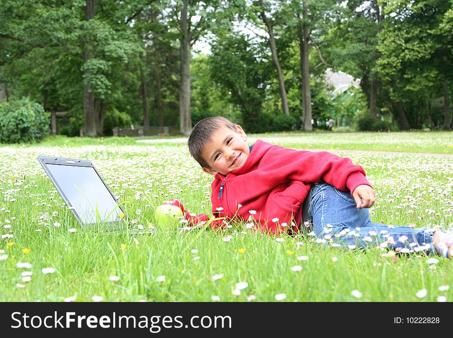 Cute little boy with laptop on a meadow. Cute little boy with laptop on a meadow