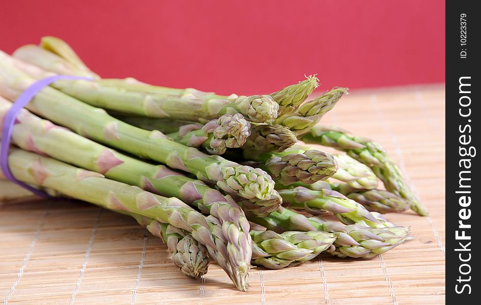 Bunch of asparagus on red background