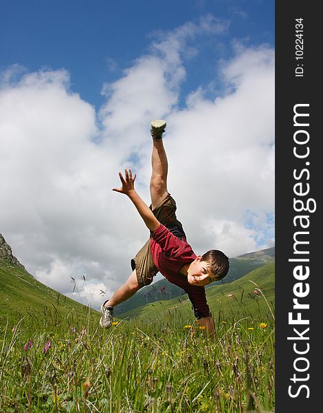 Boy dances on the meadow