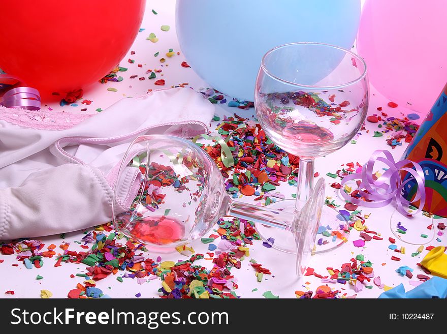 Empty glasses on a colorful party floor with balloons and confetti. Empty glasses on a colorful party floor with balloons and confetti