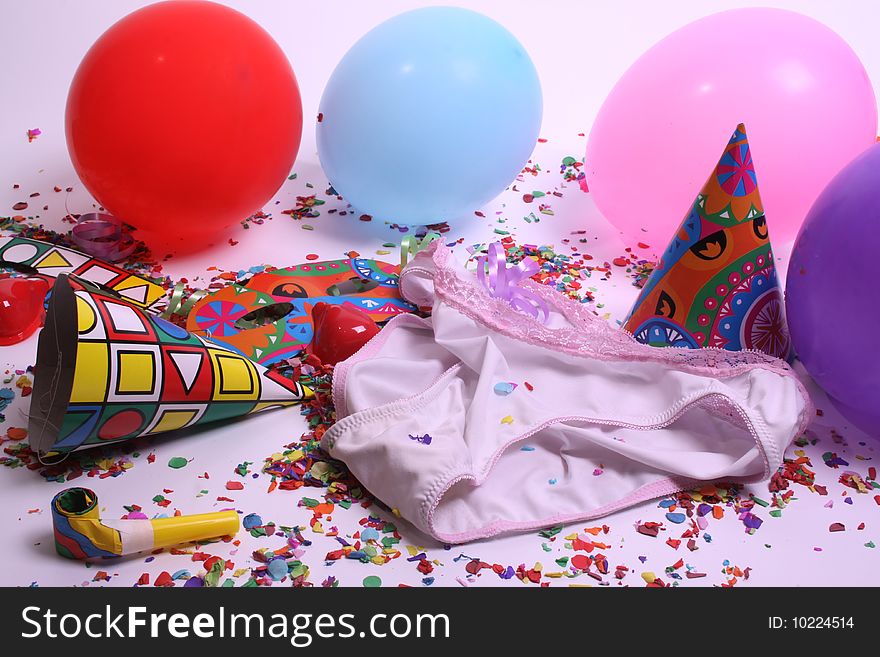 Ladies pants laying at a floor filled with party attributes, balloons and confetti. Ladies pants laying at a floor filled with party attributes, balloons and confetti