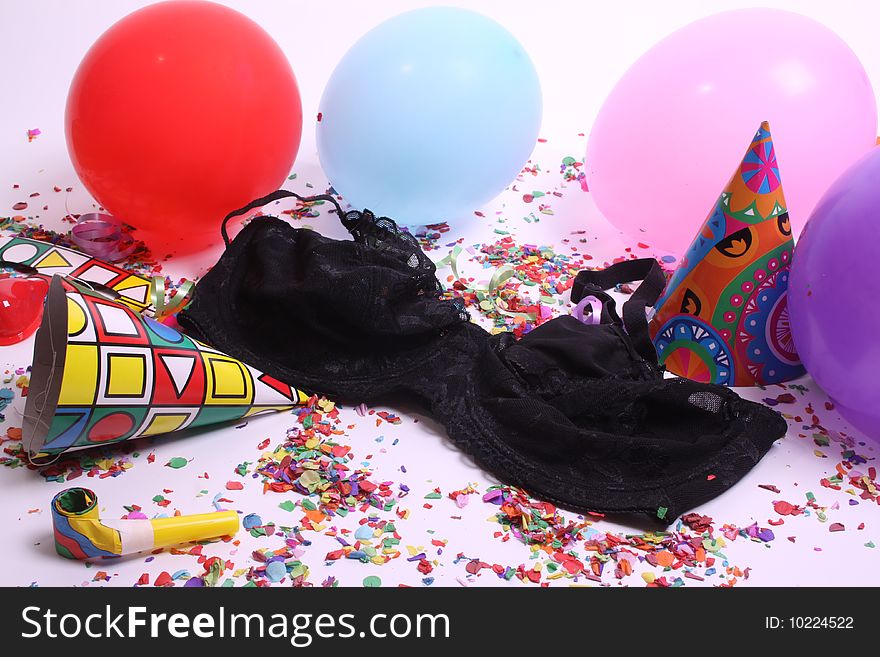 Ladies pants laying at a floor filled with party attributes, balloons and confetti. Ladies pants laying at a floor filled with party attributes, balloons and confetti