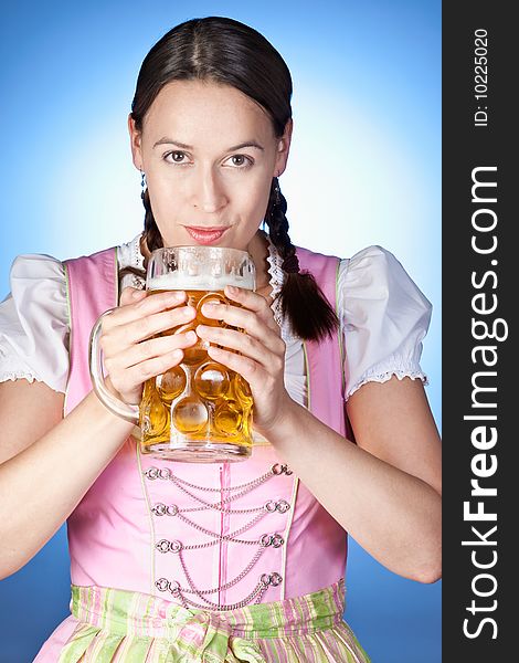 A young Bavarian girl celebrating Oktoberfest with a mass of beer. A young Bavarian girl celebrating Oktoberfest with a mass of beer