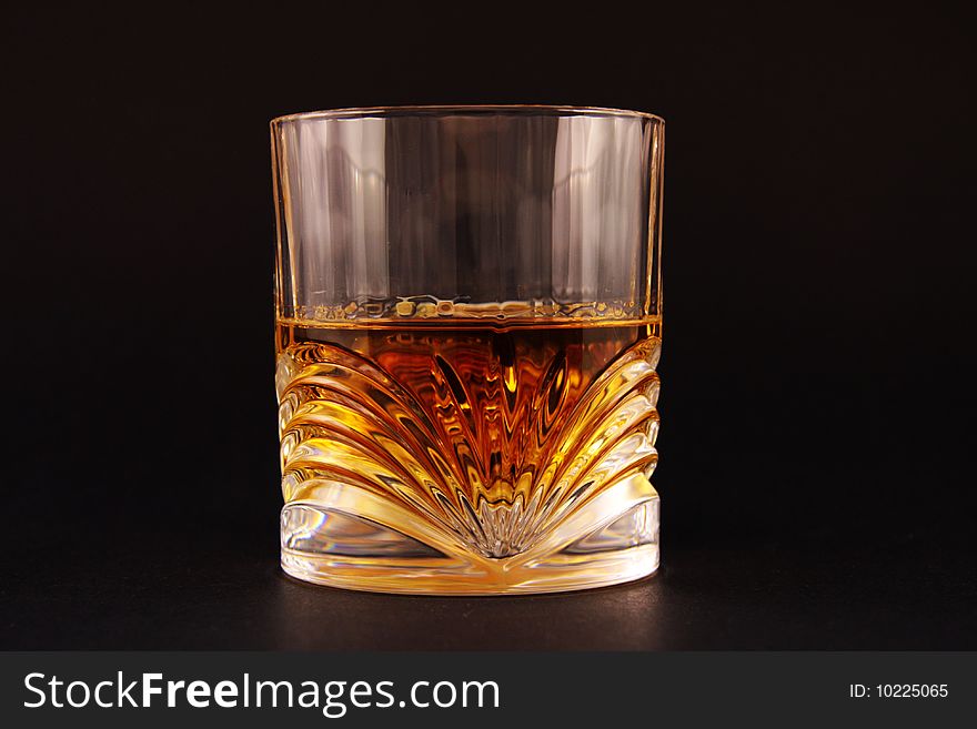 Glass with liquid on isolated black background