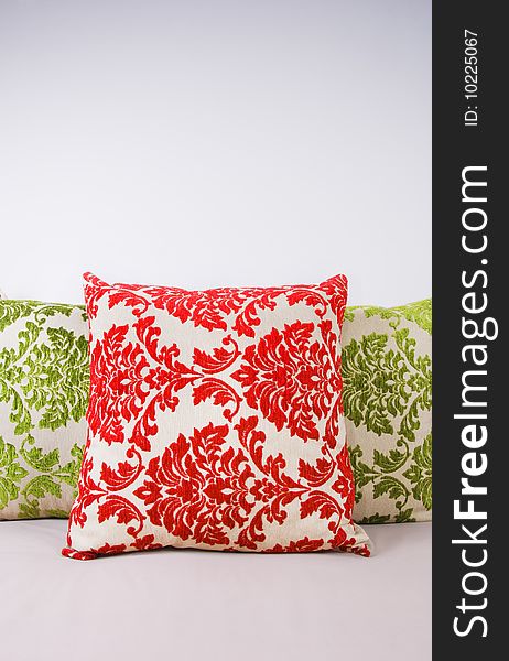 Red and green cushions againts light background
