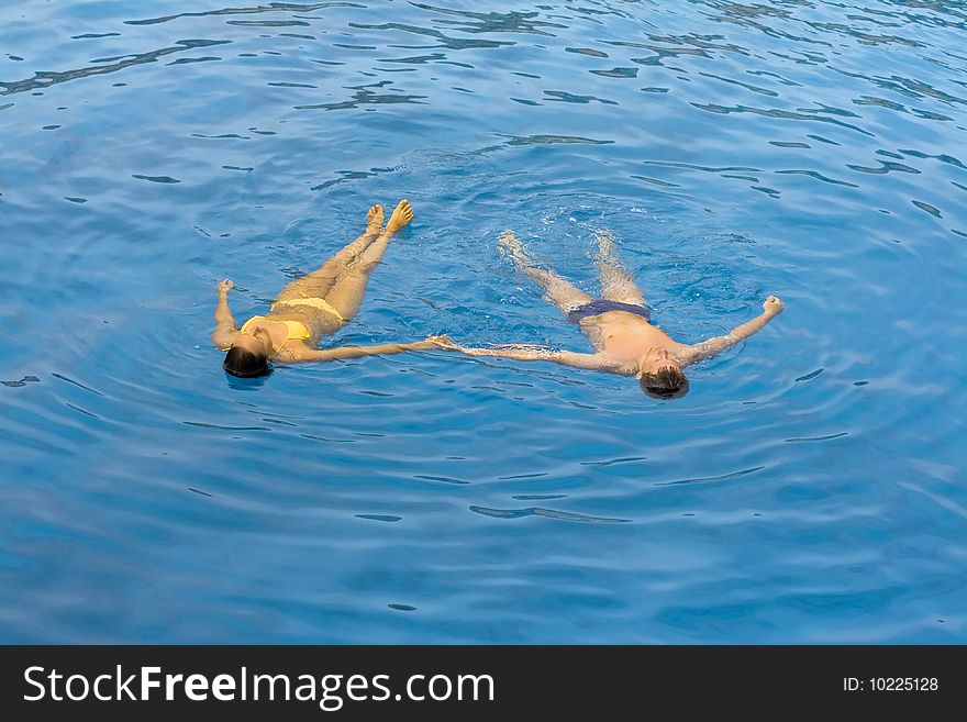 Young Couple Is Swimming In The Sea