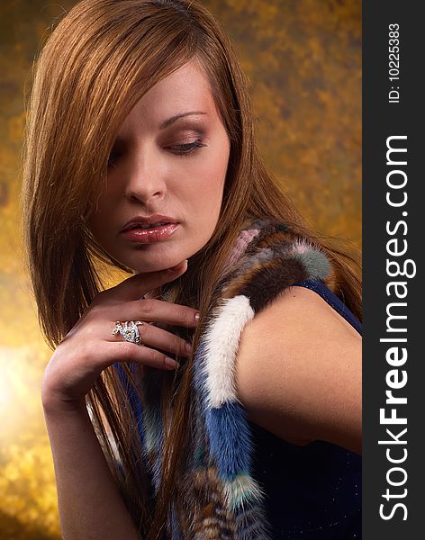 Portrait of a young beautiful brunettes, with a ring on the finger and in the fur cape blue. Portrait of a young beautiful brunettes, with a ring on the finger and in the fur cape blue