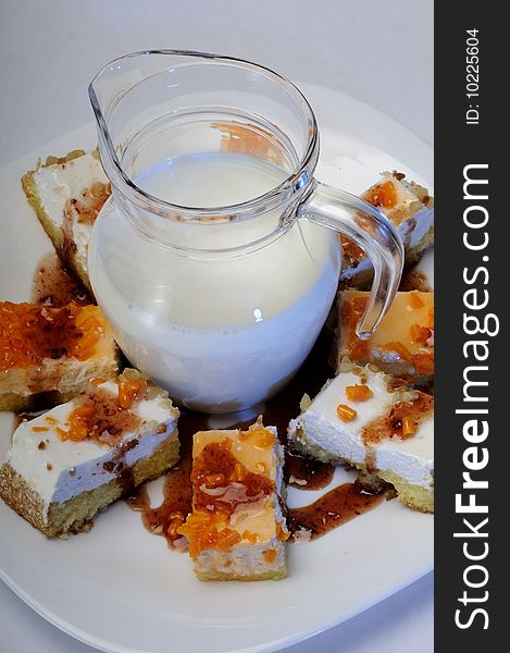 Closeup with tasty cakes on white plate and fresh milk