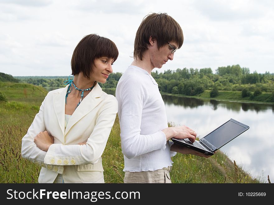 The man and women with laptop on grass