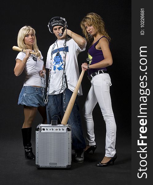 Young DJ/rapper with two teen girls and his mobile sound system isolated on black background. Young DJ/rapper with two teen girls and his mobile sound system isolated on black background