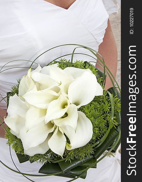 Close-up of a bridal bouquet. wedding dress in background. Close-up of a bridal bouquet. wedding dress in background.