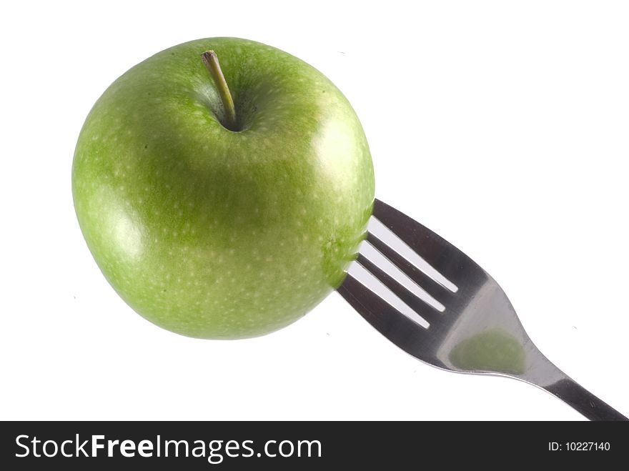 A green apple stuck on a fork, isolated on white. A green apple stuck on a fork, isolated on white.