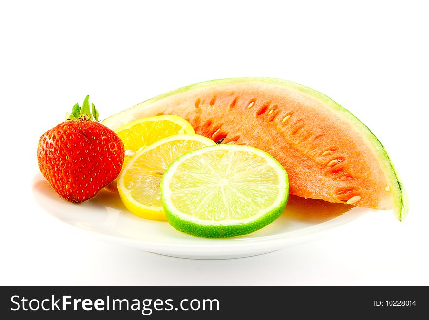 Slices of lemon, lime and orange with a ripe red strawberry and slice of juicy watermelon on a white background. Slices of lemon, lime and orange with a ripe red strawberry and slice of juicy watermelon on a white background