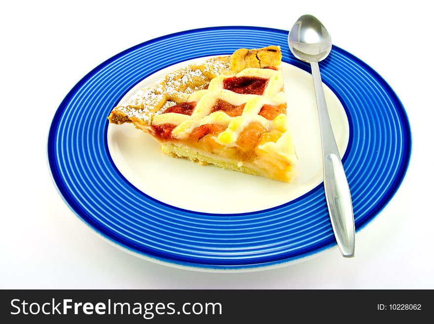 Slice of strawberry and apple pie on a blue plate with a spoon on a white background. Slice of strawberry and apple pie on a blue plate with a spoon on a white background