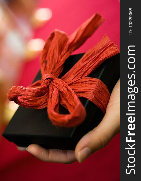 Hand Holding Gift With Red Bow