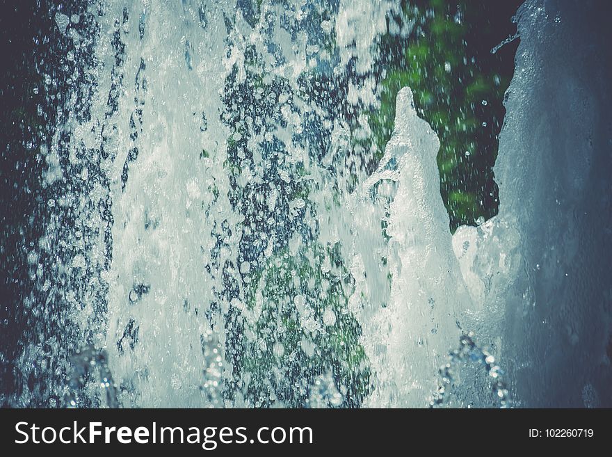 Splashing water in the city park fountain at the summer day, filtered background. Splashing water in the city park fountain at the summer day, filtered background.