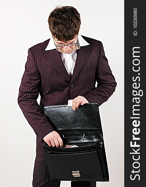 Businessman looking into bag on white