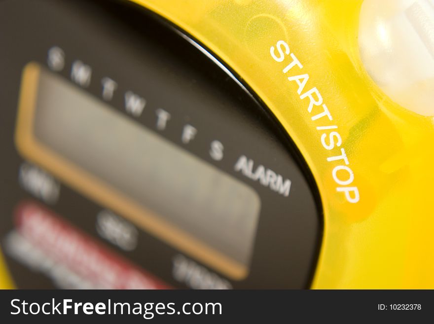 Close up of a yellow stopwatch showing the words start and stop. Close up of a yellow stopwatch showing the words start and stop