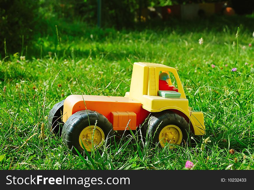 A little truck toy laying in the grass