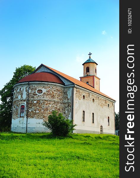 An old church on green medow with blue sky above