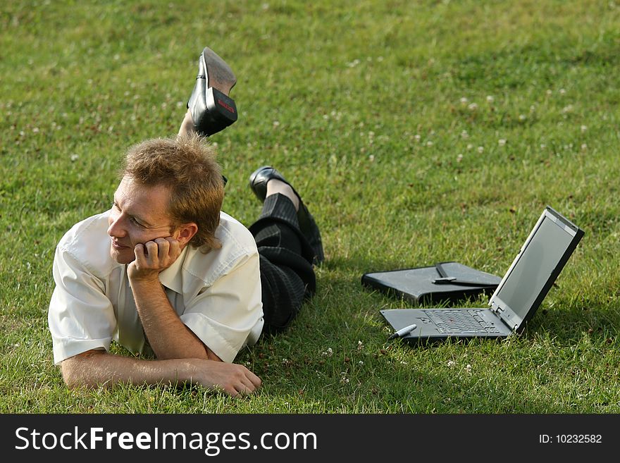 Relaxing businessman lying on the grass. Relaxing businessman lying on the grass