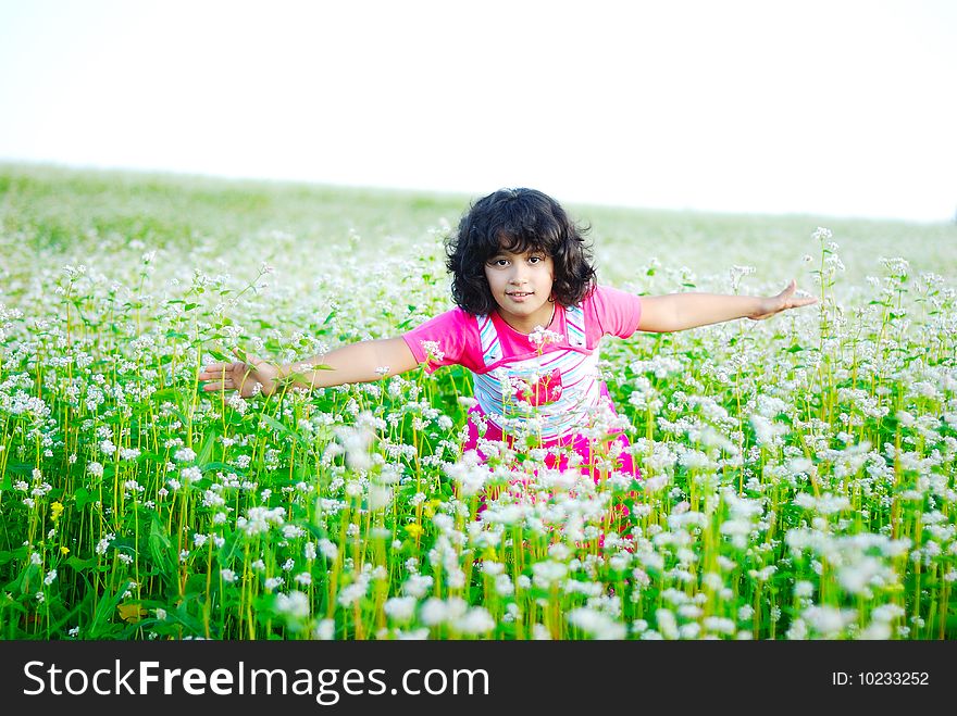 Adorable girl on green grass in nature
