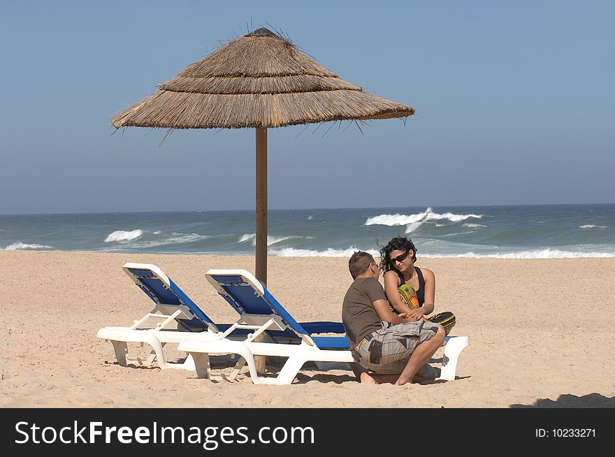 Attractive lovely couple relaxing on the beach. Attractive lovely couple relaxing on the beach
