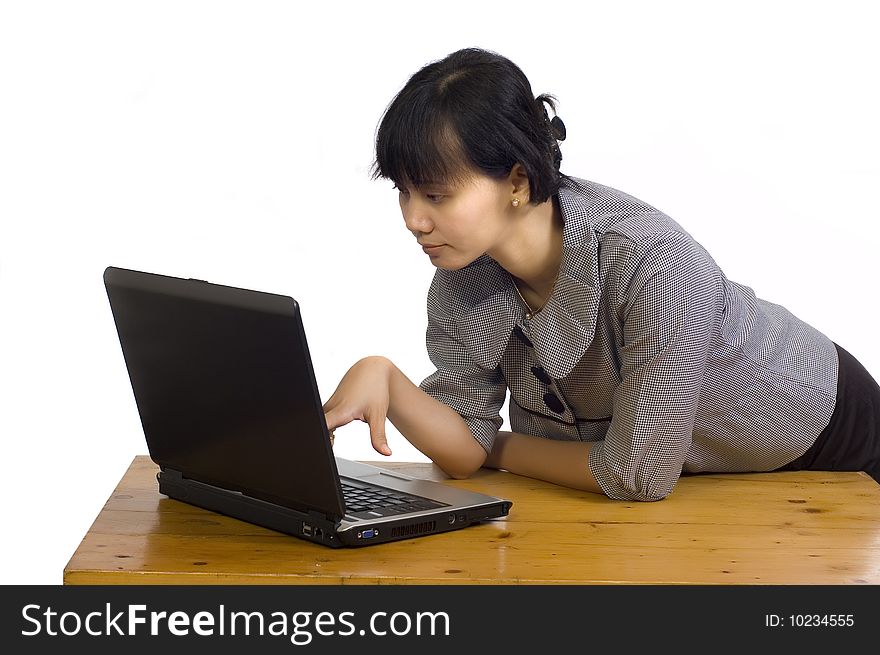 Beautiful asian business woman looking serious at her laptop on white background