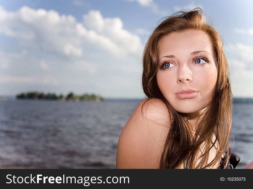 Pretty woman in sunlight near the water