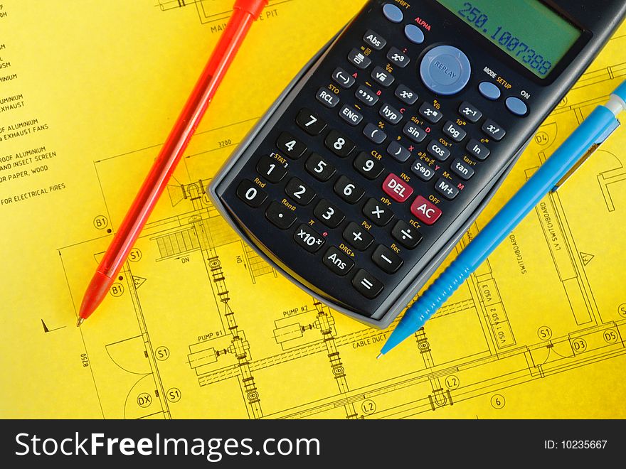Scientific calculator and pen on yellow plan