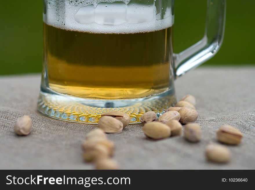 Mug with beer and pistachios. Macro. Mug with beer and pistachios. Macro.