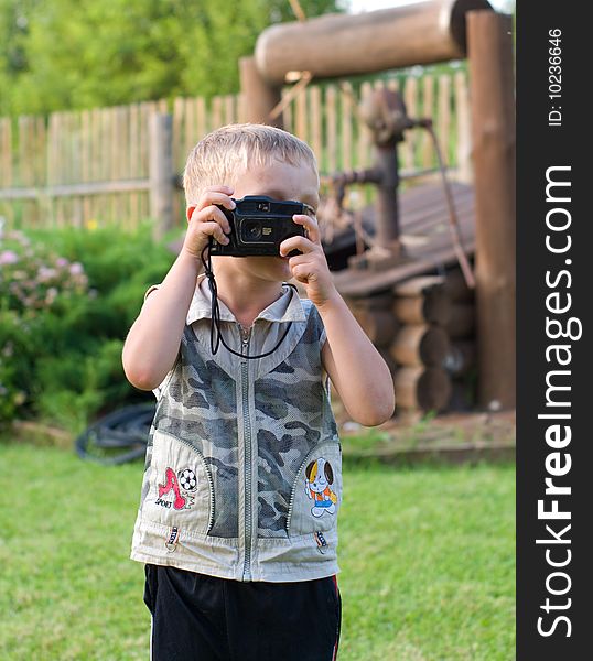 The boy photographs on a country site. The boy photographs on a country site