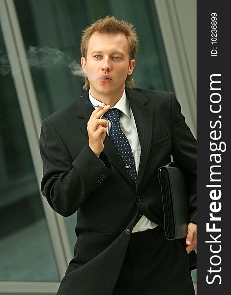 Businessman smoking on the street. Businessman smoking on the street