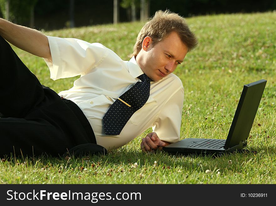 Businessman with laptop working outdoor by the sun