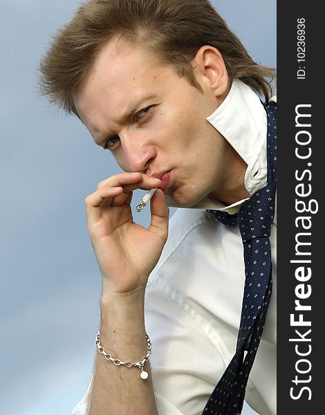 Man with necktie smoking outdoor. Man with necktie smoking outdoor