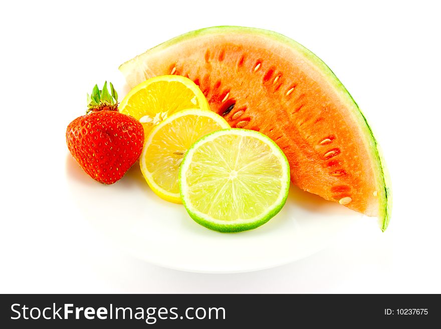 Slices of lemon, lime and orange with a ripe red strawberry and slice of juicy watermelon on a white background. Slices of lemon, lime and orange with a ripe red strawberry and slice of juicy watermelon on a white background