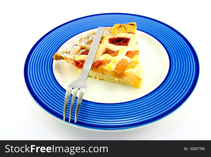 Slice of strawberry and apple pie on a blue plate with a small fork on a white background. Slice of strawberry and apple pie on a blue plate with a small fork on a white background