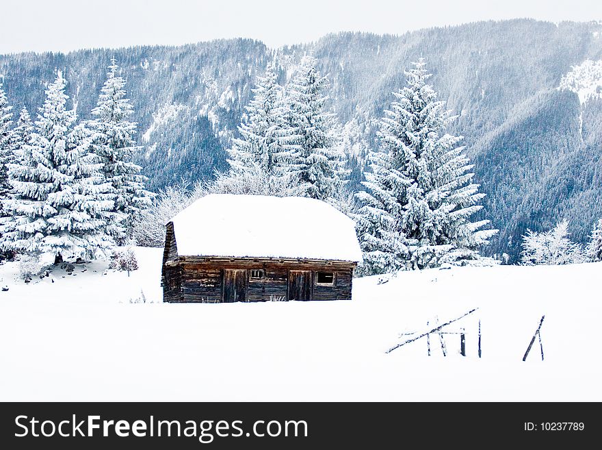 Old stable in winter in the mountains with snow