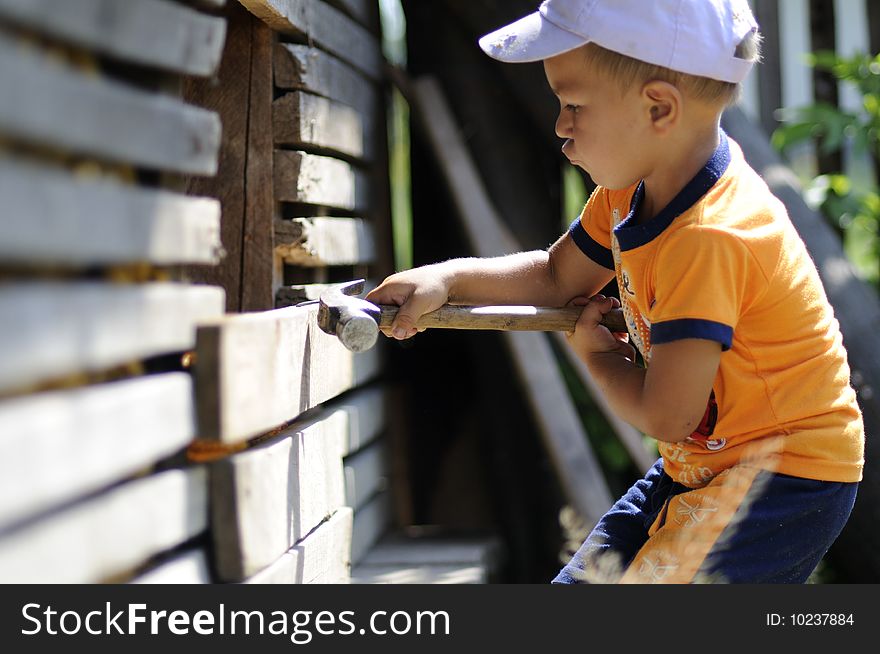 Little, cute boy playing with heavy tools