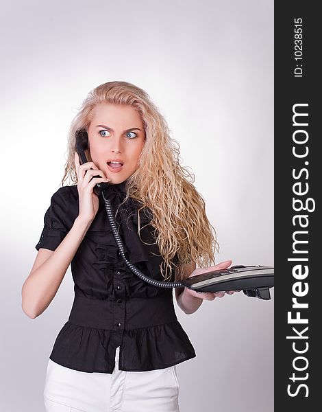 Shocked businesswoman with a phone, closeup studio shot