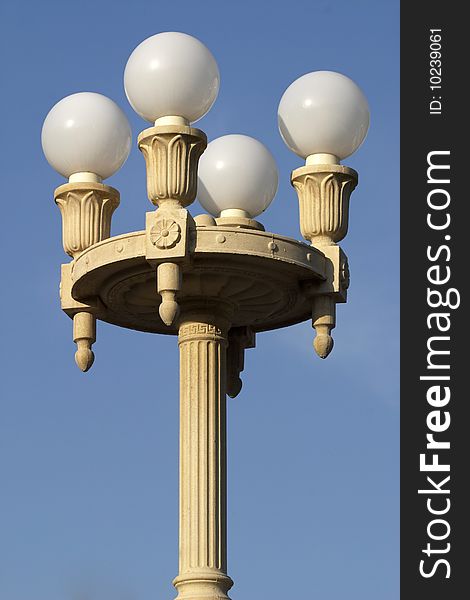 Beautiful street lamp with four matte glass balls over clear blue sky