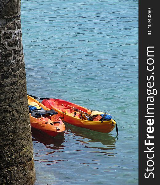 Sea Kayaks roped to a pier in San Sebastian, Spain. Sea Kayaks roped to a pier in San Sebastian, Spain