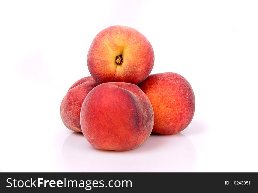 Four peaches in a stack on a white background. Four peaches in a stack on a white background.