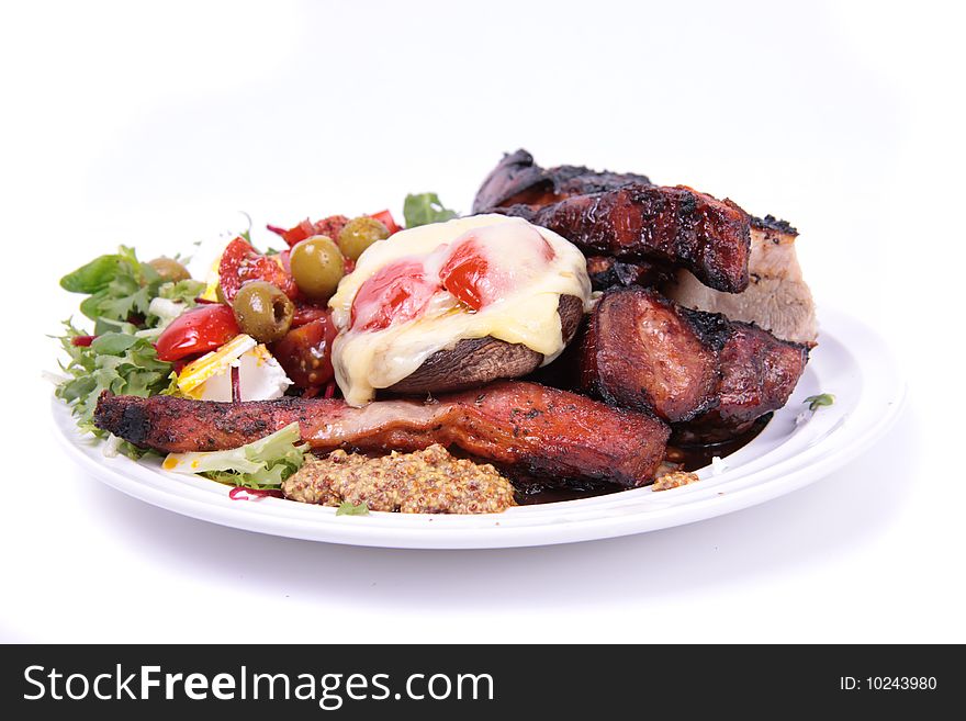 A plate of food that consist of salad with tomato and belly pork isolated on a white background. A plate of food that consist of salad with tomato and belly pork isolated on a white background.