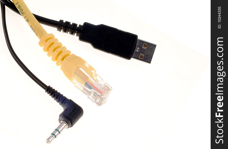 Three cables, a black USB one, a black audio one and a yellow LAN one, over a white background.