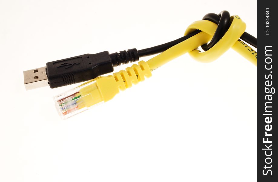 Black usb cable and yellow lan cable knotted together over a white background. Black usb cable and yellow lan cable knotted together over a white background.