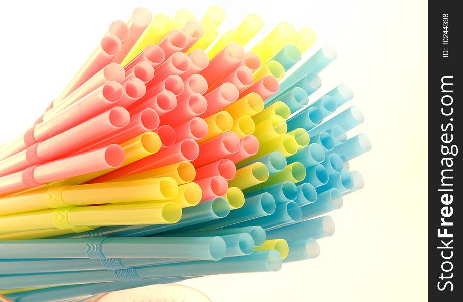 Bundle of colored drinking straws over a white background. Bundle of colored drinking straws over a white background.